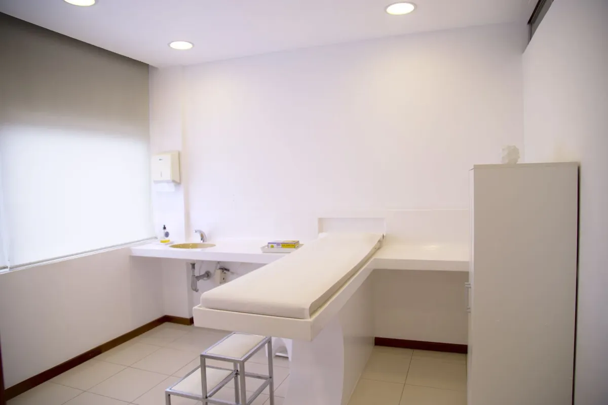 Sala de exames com maca branca e pia